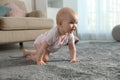 Cute little baby crawling on soft carpet