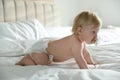 Cute little baby in diaper with pacifier lying on bed Royalty Free Stock Photo