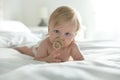 Cute little baby in diaper with pacifier lying on bed Royalty Free Stock Photo