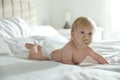 Cute little baby in diaper with pacifier lying on bed Royalty Free Stock Photo