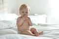 Cute little baby in diaper with pacifier sitting on bed Royalty Free Stock Photo