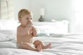 Cute little baby in diaper with pacifier sitting on bed. Space for text Royalty Free Stock Photo