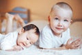 Cute little baby with elder brother lying on bed at home Royalty Free Stock Photo