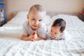 Cute little baby with elder brother lying on bed at home Royalty Free Stock Photo