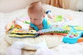 Cute little baby with ginger hair and blue eyes reading a book o Royalty Free Stock Photo