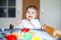 Cute little baby girl baking gingerbread Christmas cookies at home. Adorable blond happy healthy child having fun in Royalty Free Stock Photo