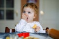 Cute little baby girl baking gingerbread Christmas cookies at home. Adorable blond happy healthy child having fun in Royalty Free Stock Photo