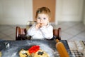 Cute little baby girl baking gingerbread Christmas cookies at home. Royalty Free Stock Photo