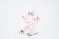 Cute little baby girl in colorful winter clothes making snow angel, laying down on snow. Active outdoors leisure with Royalty Free Stock Photo