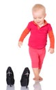 Cute little baby girl trying on her mother's shoes on white back Royalty Free Stock Photo