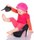 Cute little baby girl trying on her mother's shoes on white back Royalty Free Stock Photo