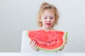 Cute little baby girl eating watermelon slice on light background Royalty Free Stock Photo