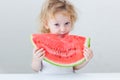 Cute little baby girl eating watermelon slice on light background Royalty Free Stock Photo