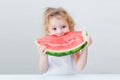 Cute little baby girl eating watermelon slice on light background Royalty Free Stock Photo