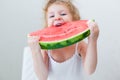 Cute little baby girl eating watermelon slice on light background Royalty Free Stock Photo