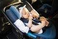 Little baby fastened with security belt in safety car seat. Royalty Free Stock Photo