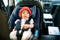 Little baby fastened with security belt in safety car seat. Royalty Free Stock Photo