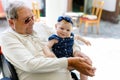 Cute little baby girl with grandfather on summer day in garden Royalty Free Stock Photo