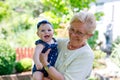 Cute little baby girl with grandmother on summer day in garden Royalty Free Stock Photo