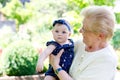 Cute little baby girl with grandmother on summer day in garden Royalty Free Stock Photo