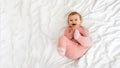 Cute little baby girl having fun and smiling, lying on bed at home, panorama with free space, top view Royalty Free Stock Photo