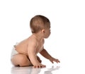 Cute little baby girl infant in diaper try to creep on floor looking at the corner isolated on white background