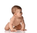 Cute little baby girl infant in diaper try to creep on floor looking at the corner isolated on white background