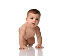 Cute little baby girl infant in diaper try to creep on floor smiling and looking aside isolated on white background