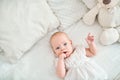 Cute little baby girl lying on bed, finger in mouth Royalty Free Stock Photo