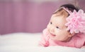 Cute little baby girl lying in the bed in pink dress Royalty Free Stock Photo