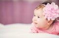 Cute little baby girl lying in the bed in pink dress Royalty Free Stock Photo