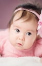 Cute little baby girl lying in the bed in pink dress Royalty Free Stock Photo