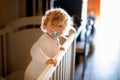 Cute Little Baby Girl Lying in Cot after Sleeping. Healthy Happy Child in Bed Climbing Out. Danger for Babies and Royalty Free Stock Photo