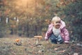 Cute little girl picking mushrooms in summer forest, looks at non edible poisonous mushrooms toadstools in forest, kids Royalty Free Stock Photo