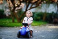 Cute little baby girl playing with blue small toy car in garden of home or nursery. Adorable beautiful toddler child Royalty Free Stock Photo