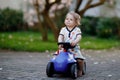 Cute little baby girl playing with blue small toy car in garden of home or nursery. Adorable beautiful toddler child Royalty Free Stock Photo