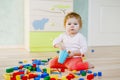 Cute little baby girl playing with educational toys. Happy healthy child having fun with colorful different wooden Royalty Free Stock Photo