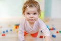 Cute little baby girl playing with educational toys. Happy healthy child having fun with colorful different wooden Royalty Free Stock Photo