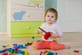 Cute little baby girl playing with educational toys. Happy healthy child having fun with colorful different wooden Royalty Free Stock Photo