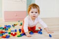 Cute little baby girl playing with educational toys. Happy healthy child having fun with colorful different wooden Royalty Free Stock Photo