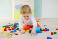 Cute little baby girl playing with educational toys. Happy healthy child having fun with colorful different wooden Royalty Free Stock Photo
