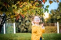 little baby girl is playing with glasses and smiling outdoors.Sunny autumn day in the park, yellow light. soon to school Royalty Free Stock Photo