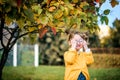 little baby girl is playing with glasses and smiling outdoors.Sunny autumn day in the park, yellow light. soon to school Royalty Free Stock Photo