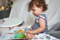 Cute little baby girl reading a picture book on a white sofa Royalty Free Stock Photo