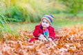 Cute little baby girl in a red coat in autumn park Royalty Free Stock Photo