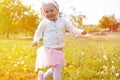 Cute little baby girl running in green park at sunset summer. Happy child playing having fun outdoor. Royalty Free Stock Photo