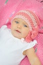 A cute little baby girl is staring up and is on a pink blanket Royalty Free Stock Photo