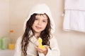 Beautiful toddler girl taking a bath in a bathtub with bubbles. Cute kid washing his hair with shampoo in the shower. Royalty Free Stock Photo