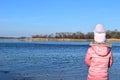 Cute little girl playing near the lake in the autumn park