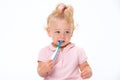 Cute little baby girl 1 year old in pink t-shirt brushing her teeth isolated on white background Royalty Free Stock Photo